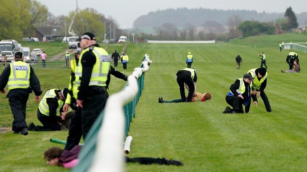 Animal Rising activists are apprehended by police officers as they attempted to invade the race course ahead of the Grand National at Ayr Racecourse