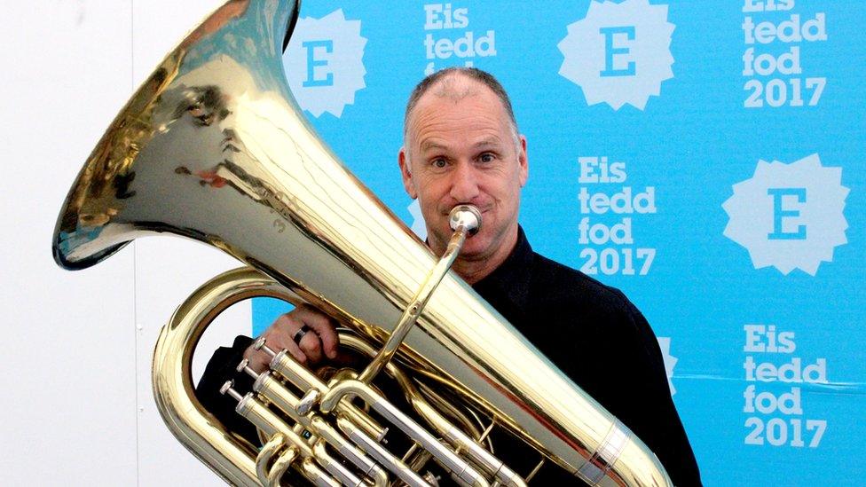 Allan o wynt? Bydd Neil 'Maffia' Williams yn chwarae ym mand Bryn Fôn heno ar ôl cystadlu gyda Seindorf Dyffryn Nantlle yn gynharach // Tuba player Neil Williams won't get much chance to catch his breath. He's following up his stint on the Eisteddfod stage with an appearance at a gig tonight!