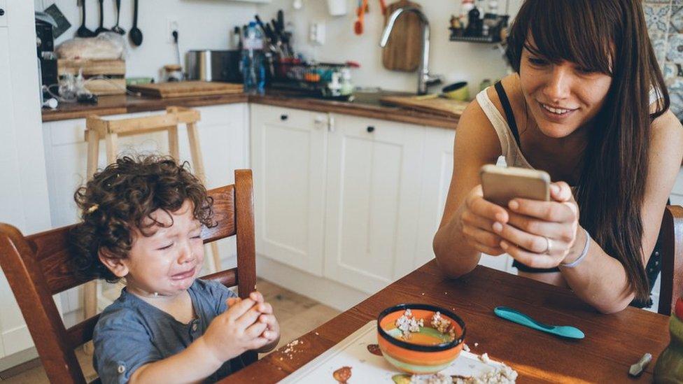 Image of child crying whilst mum is on phone