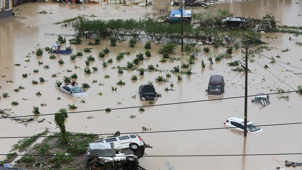 Cars are partially submerged in flood water