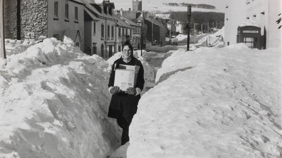 Lady carrying provisions in deep snow