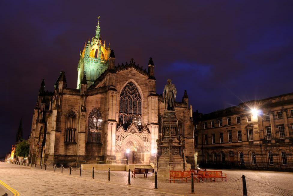 The cathedral is light up against a dark sky.