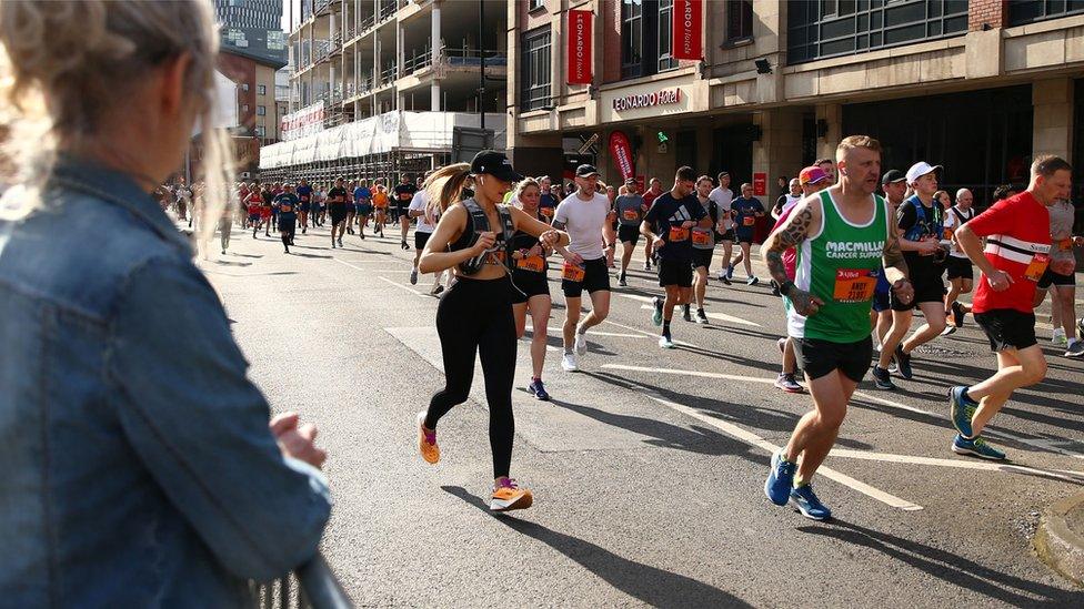 female bystander watches runner race past