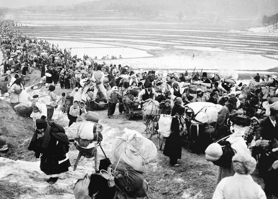 Unlocated picture taken 18 January 1951, shows Korean refugees fleeing to the south, as they are passing by frozen rice fields.