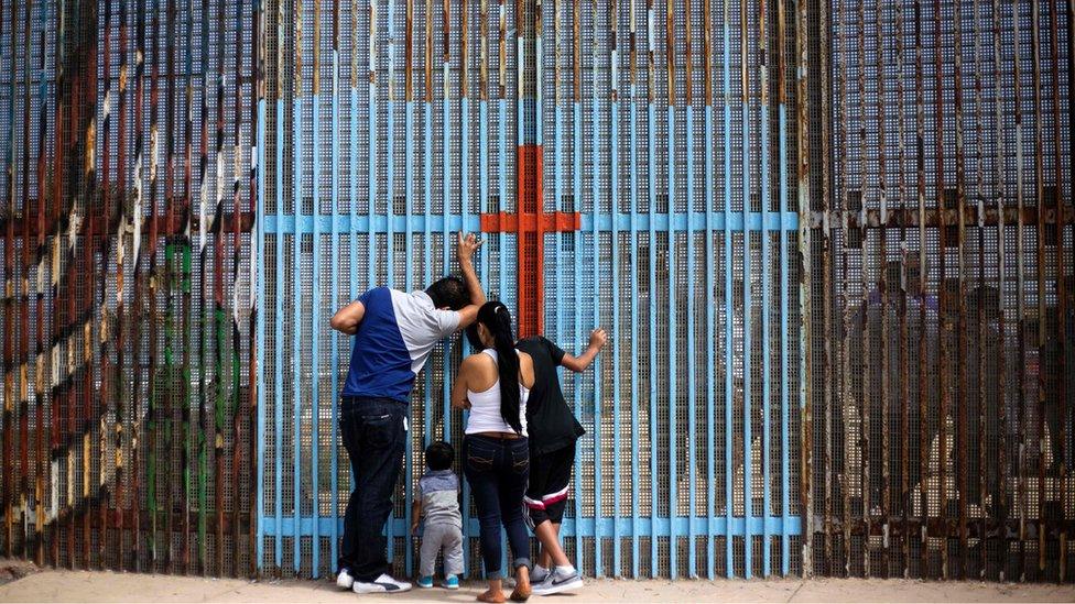 A family talks with with relatives through the US - Mexico border fence in Playas de Tijuana, in Tijuana, northwestern Mexico, on July 2, 2016