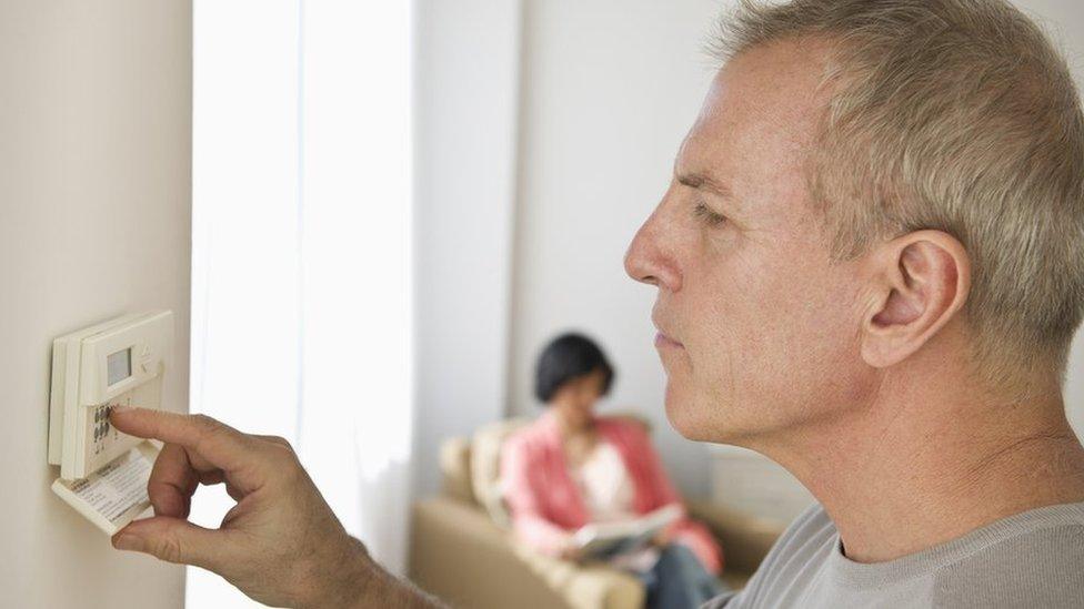 Man adjusting thermostat