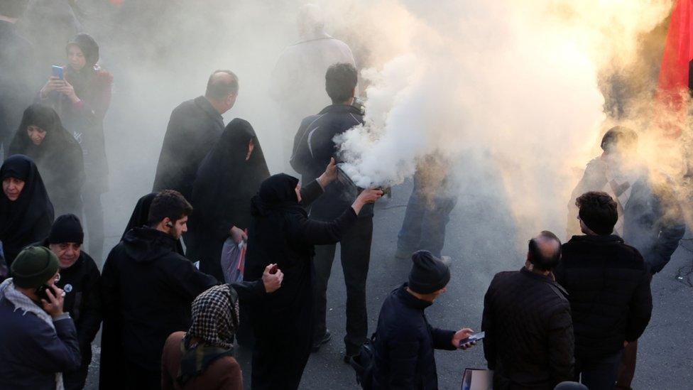 A woman burns incense as crowds gather to pay homage to Iranian military commander Qasem Soleimani, Iraqi paramilitary chief Abu Mahdi al-Muhandis and other victims of a US attack, in the capital Tehran on January 6, 2020