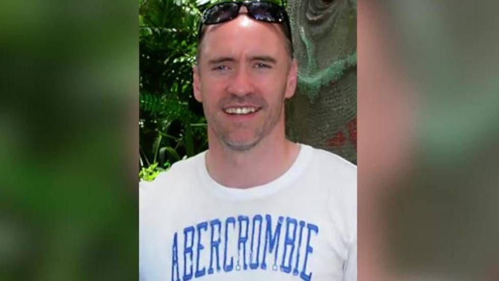 Paul Doyle wears a white Abercrombie T-shirt and has sunglasses atop his head.