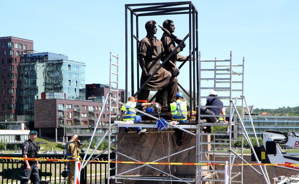 Workers removing one of the Soviet-era statues on the bridge