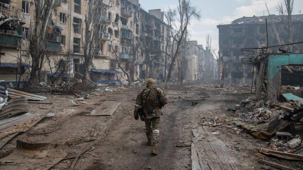 A Russian soldier walks in the ruins of Mariupol in 2022