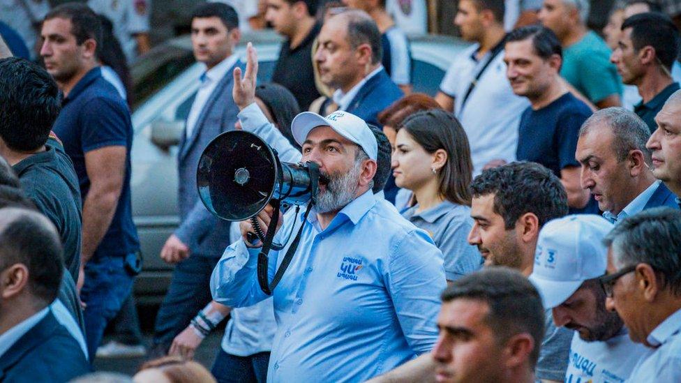 Nikol Pashinyan talks with a loudhailer to his supporters in a march through the streets of Yerevan