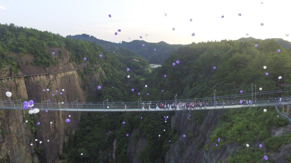 Couples and well wishes release balloons above Shiniuzhai glass bridge, 21 July 2016