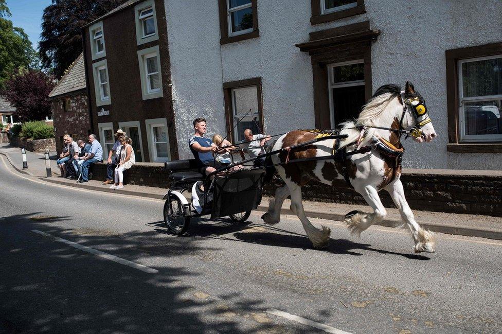 People travel along The Sands street by horse and trap