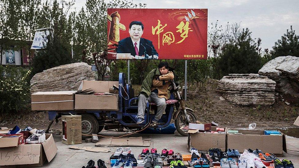 A vendor in a Chinese city under a "China Dream" sign