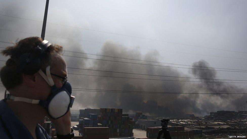 Smoke billows from the site of two explosions at Tianjin