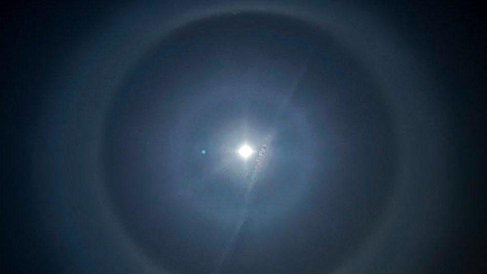 Moon halo with a streak of cloud in front