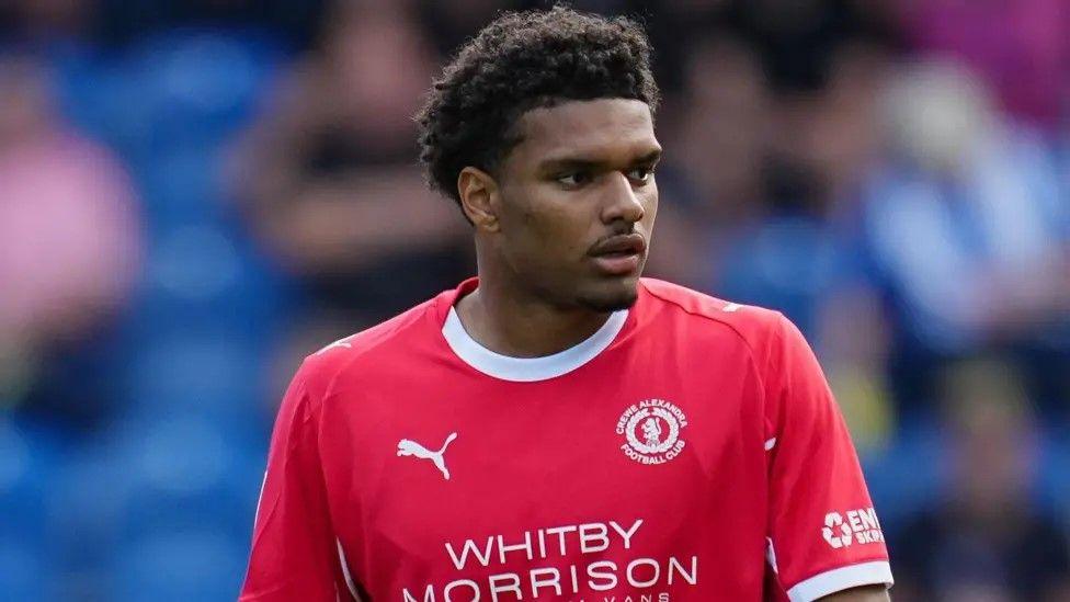 James Golding looking to his left wearing Crewe Alexandra home red kit