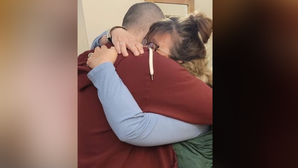 Angela Wood giving her son, Aiden Aslin, a hug following his return to the UK