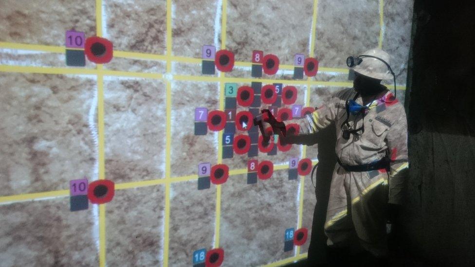 A trainee use an electronic "spray can" to mark out blast holes