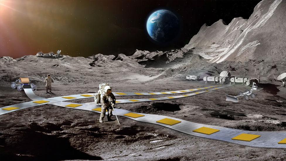 An artist's impression of what a lunar railway might look like, showing astronauts walking next to a track with magnets on the Moon