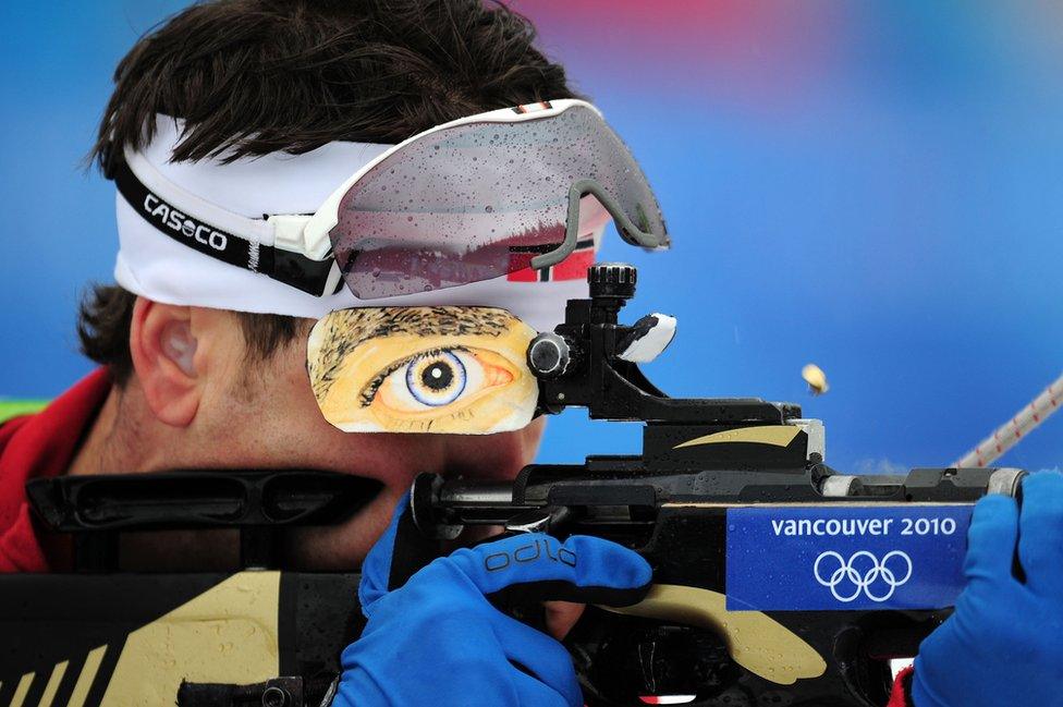 Ole Einar Bjoerndalen of Norway shoots his rifle.