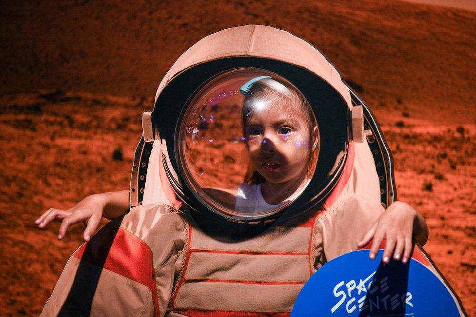 A young girl looks at an exhibit during the Apollo 11, 50th Live celebration at Space Center Houston