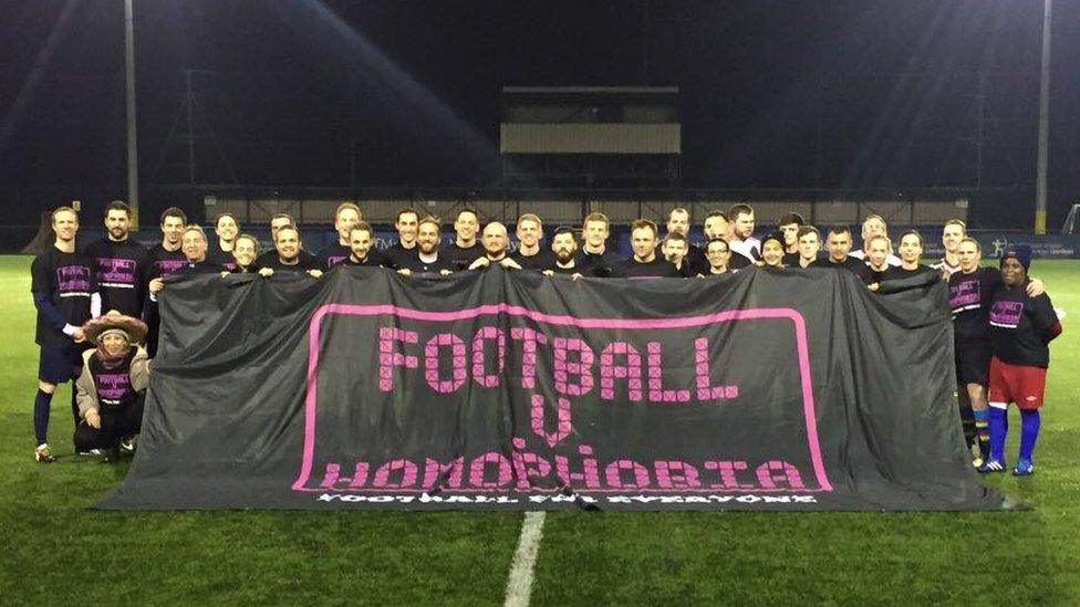 Footballers holding up a Football V Homophobia banner