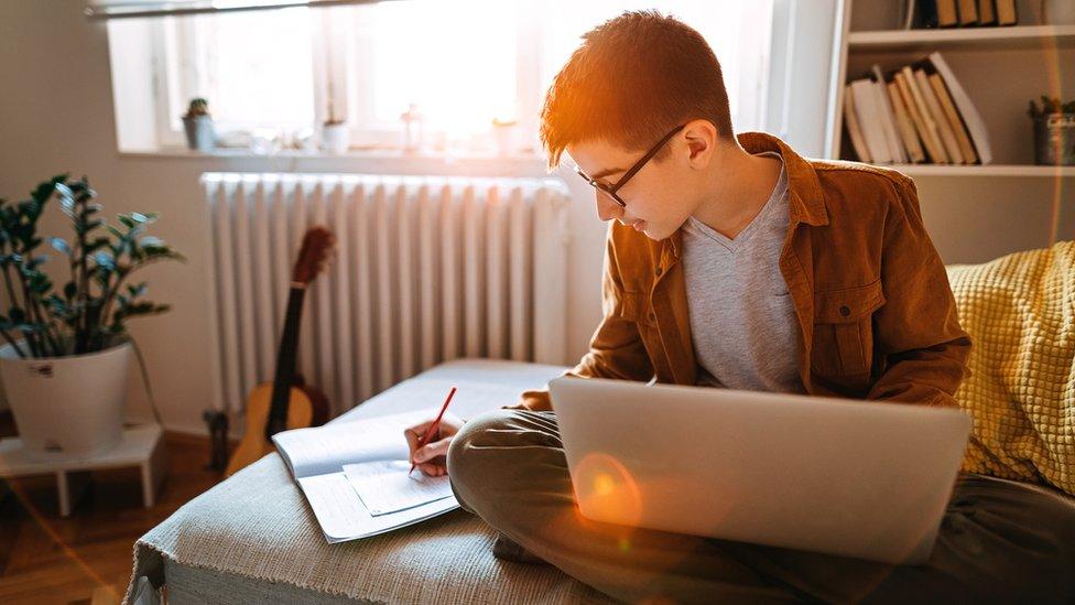 A teenage boy studying at home