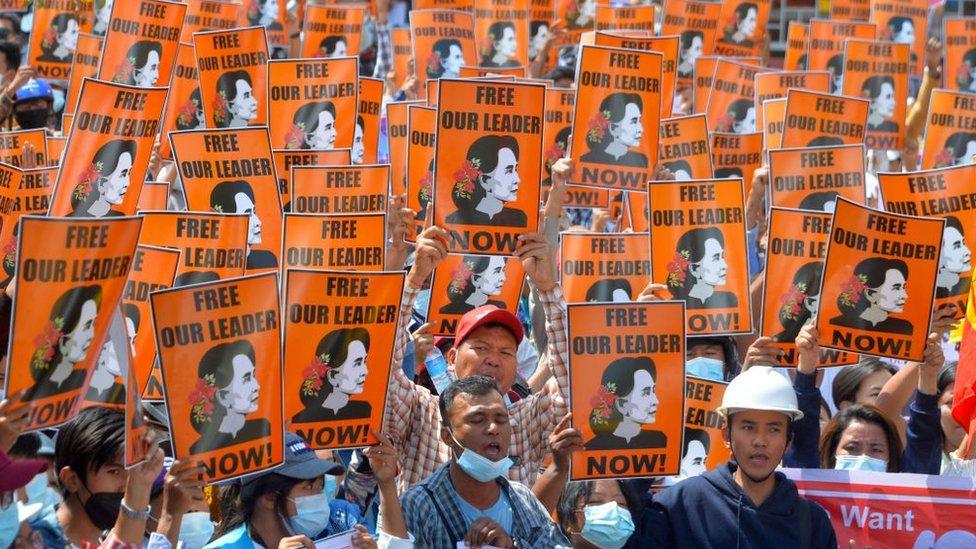 Protesters hold posters with the image of detained civilian leader Aung San Suu Kyi during a demonstration against the military coup in Naypyidaw