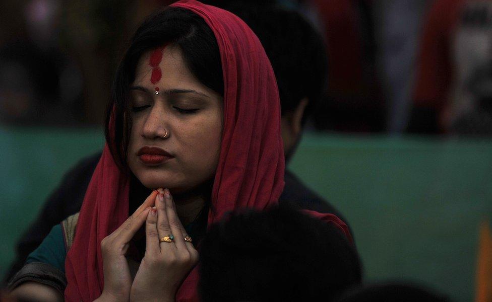 An Indian Hindu devotee offers prayers to the sun during the Chhath Festival in Siliguri on November 8, 2013