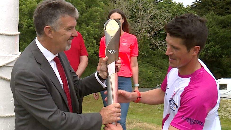 Laurence Skelly being handed the baton by Christian Varley