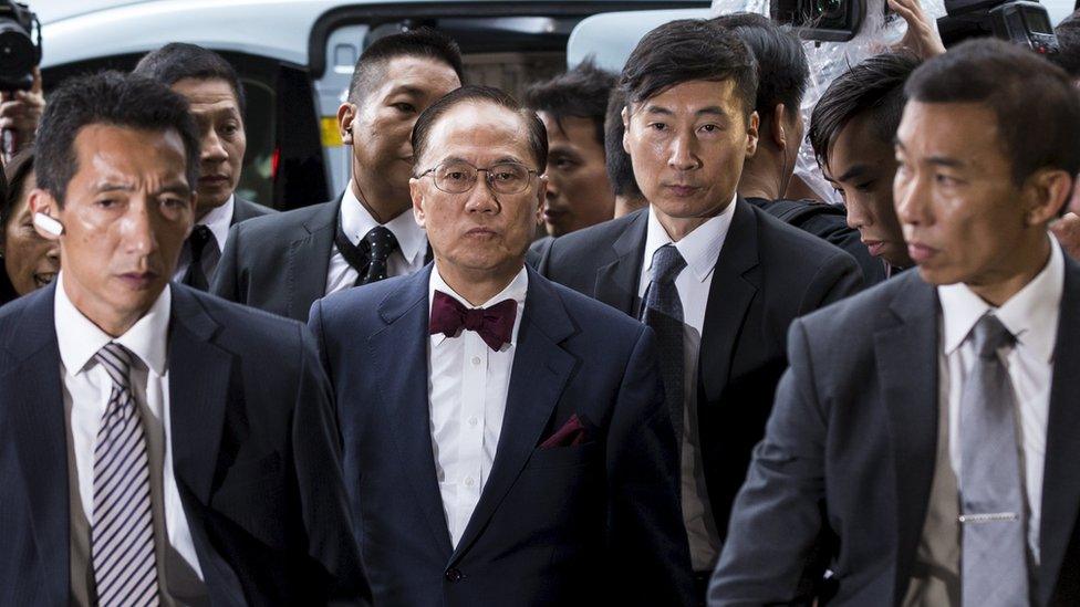 Former Hong Kong Chief Executive Donald Tsang (centre) is escorted by two policemen as he walks into the Eastern Law Court in Hong Kong