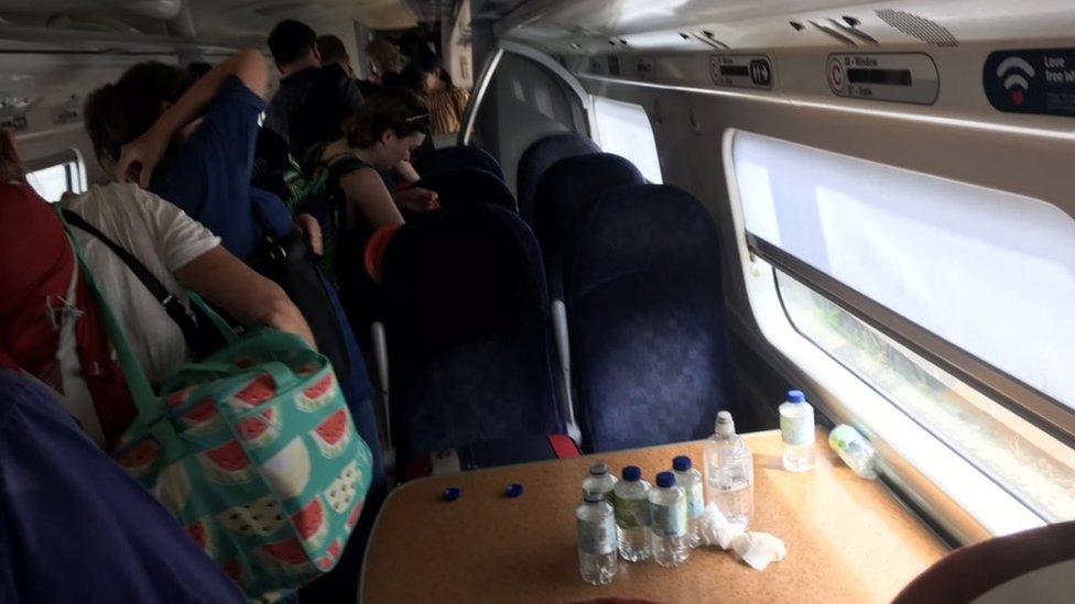 Passengers and water bottles on crowded train