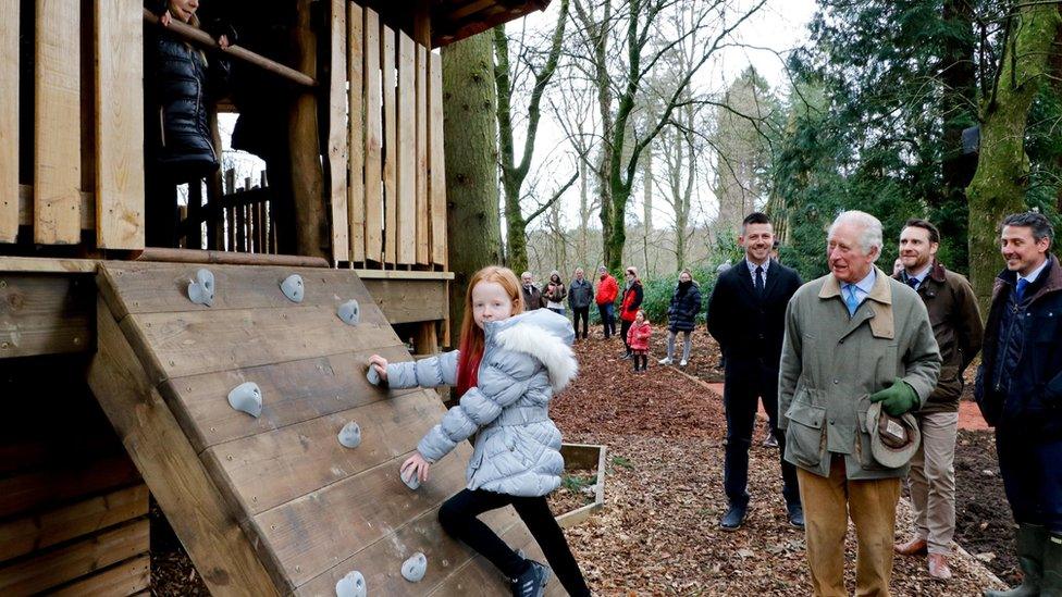 Prince Charles encourages girl on climbing wall