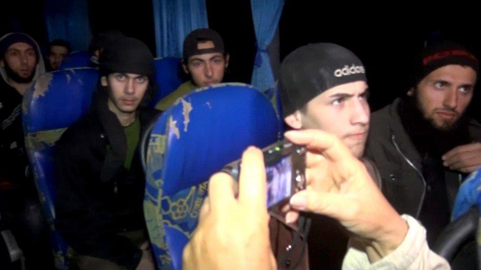 Syrian rebel fighters sit on a bus