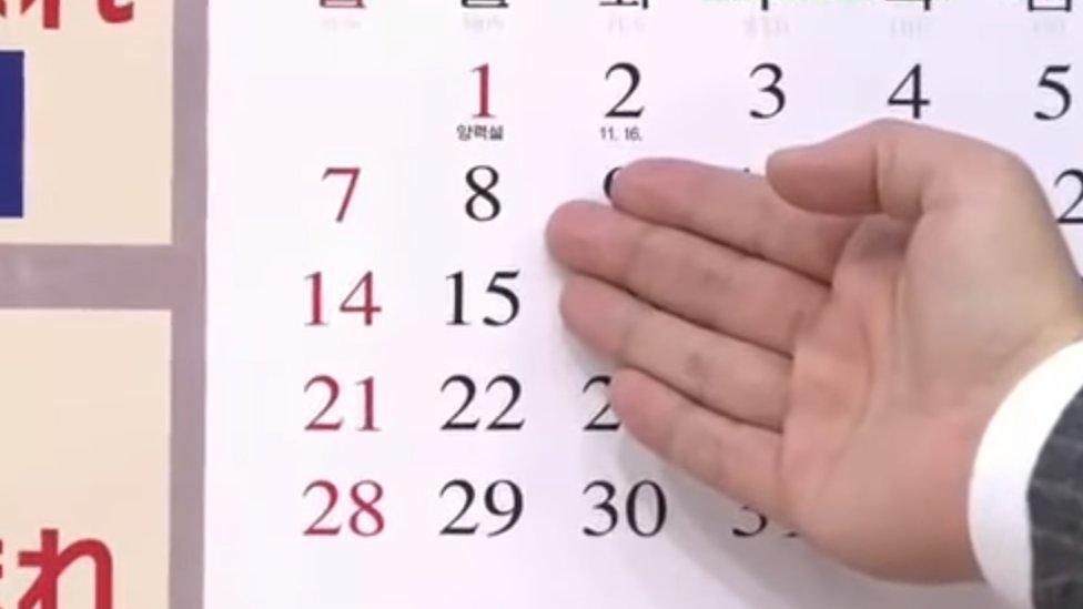 A TV presenter points to 8 January on a North Korean calendar