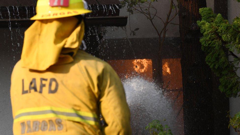 A firefighter douses flames in a California home.