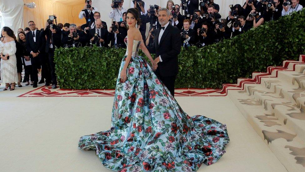 Actor George Clooney and his wife Amal Clooney arrive on the red carpet.