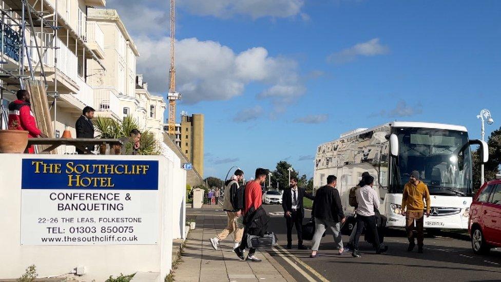 Asylum seekers boarding a bus outside a hotel in Folkestone