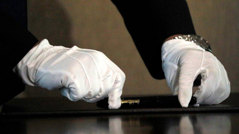 A North Korean aide places the pen for North Korea's leader Kim Jong-un before a signing ceremony with US President Donald Trump in Singapore, 12 June 2018