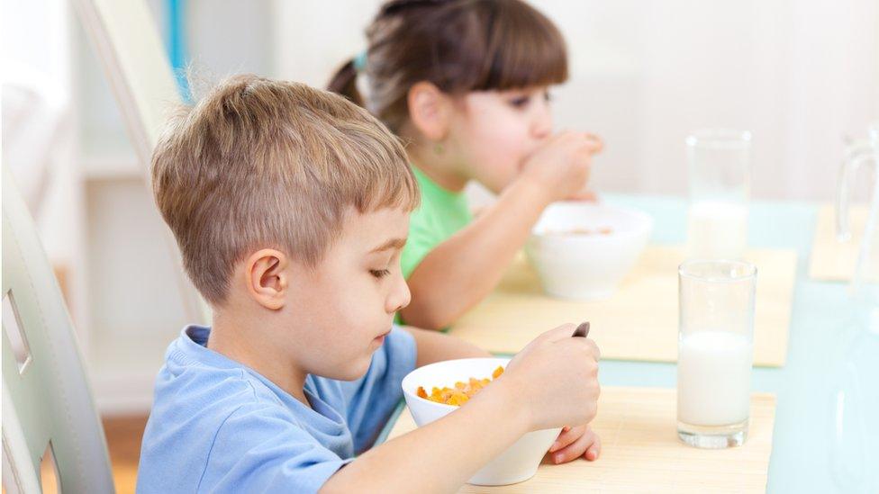 Boy and girl eating cereal