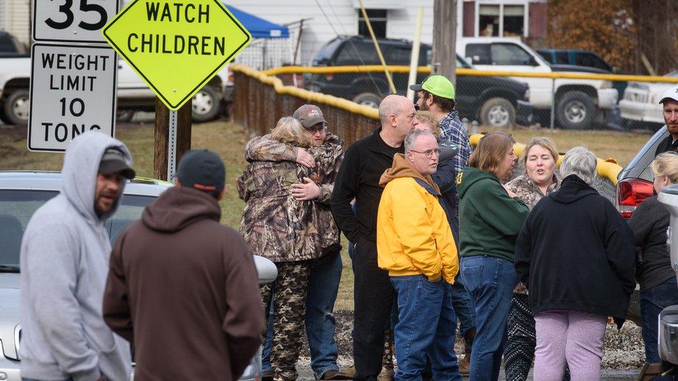 Family and friends console one another after the shooting