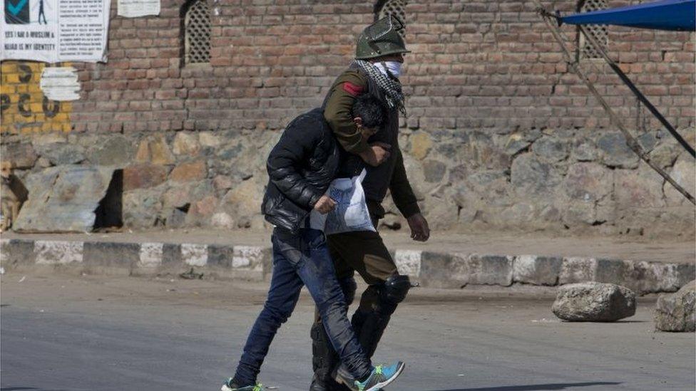 An Indian policeman detains a Kashmiri Muslim youth caught taking photographs with his cellphone during a protest in Srinagar, Indian controlled Kashmir, Friday, Feb. 26, 2016.