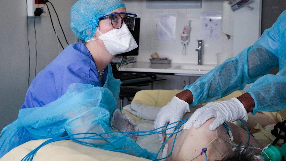 Nursing assistants tend to a patient infected with the coronavirus (Covid-19) at the reanimation unit of the Antoine Beclere AP-HP hospital in Clamart, outside Paris, on December 23, 2021