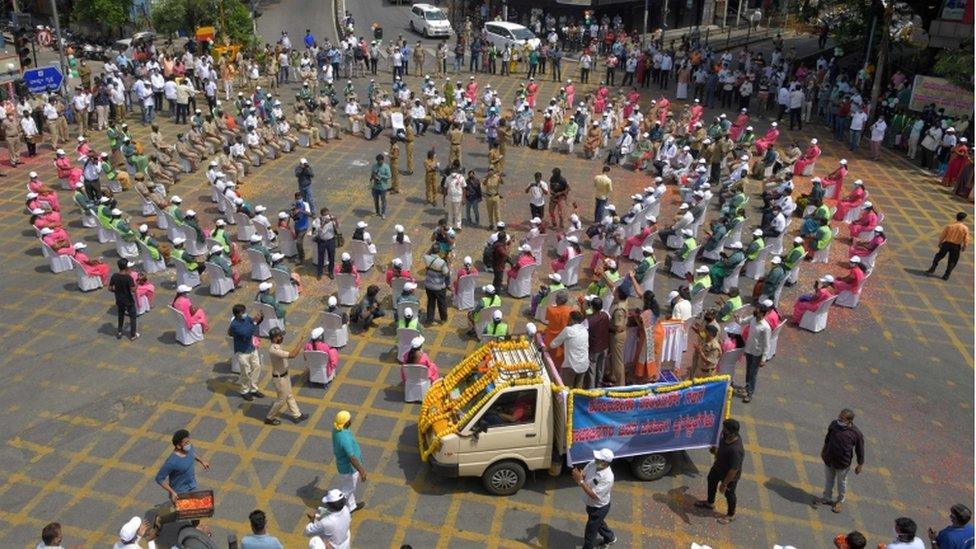 People shower flower petals on frontline workers during a tribute to people fighting against the spread of coronavirus, in Bangalore on May 10, 2020