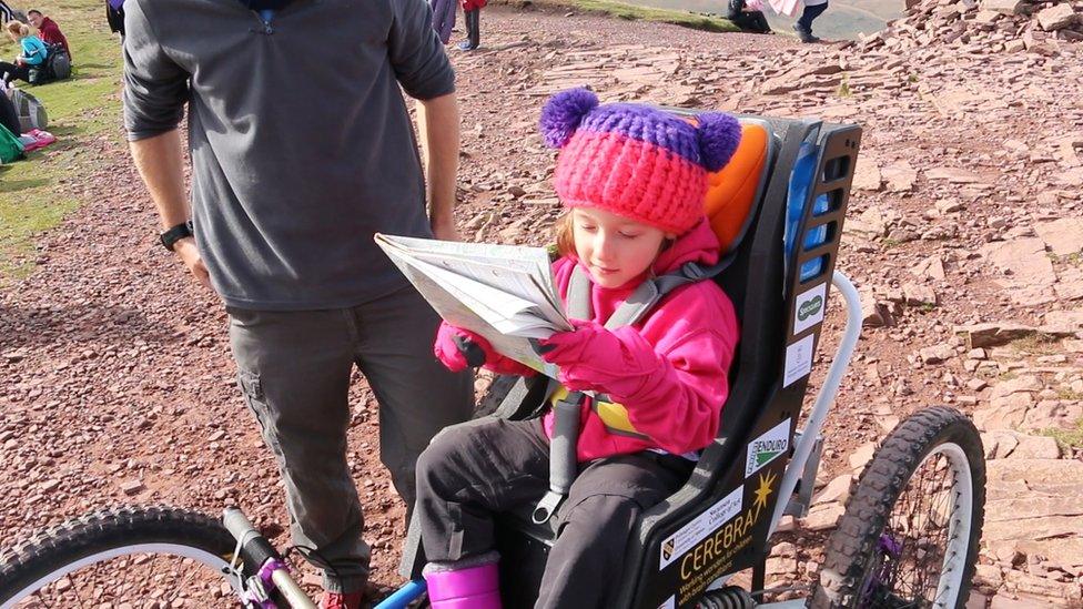 Imogen holding a map on the route to the top of the mountain