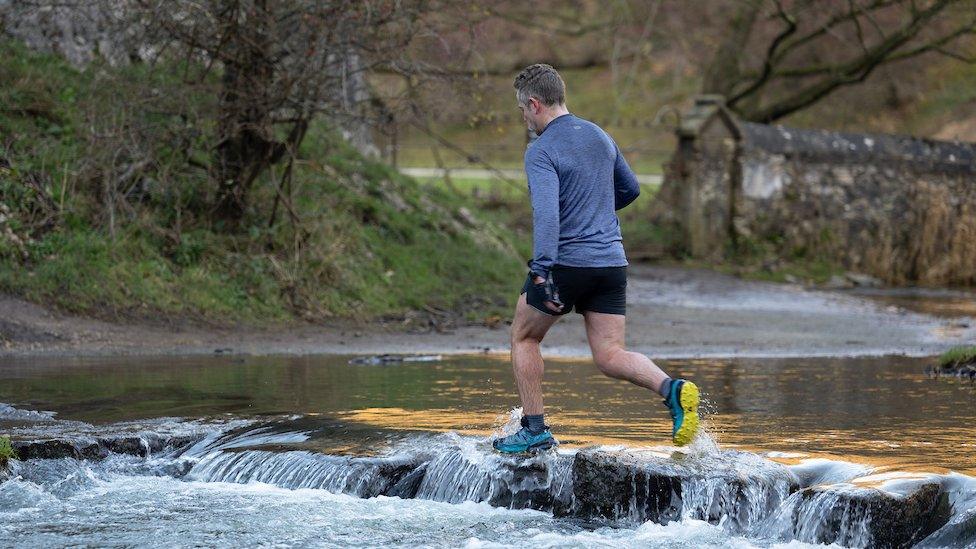 A runner leaps over the dislodged stones on 24 November 2023