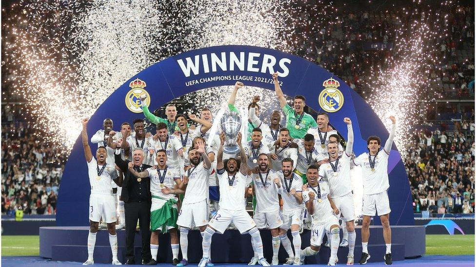 Real Madrid players celebrate their win against liverpool with light displays and confetti on the pitch in paris