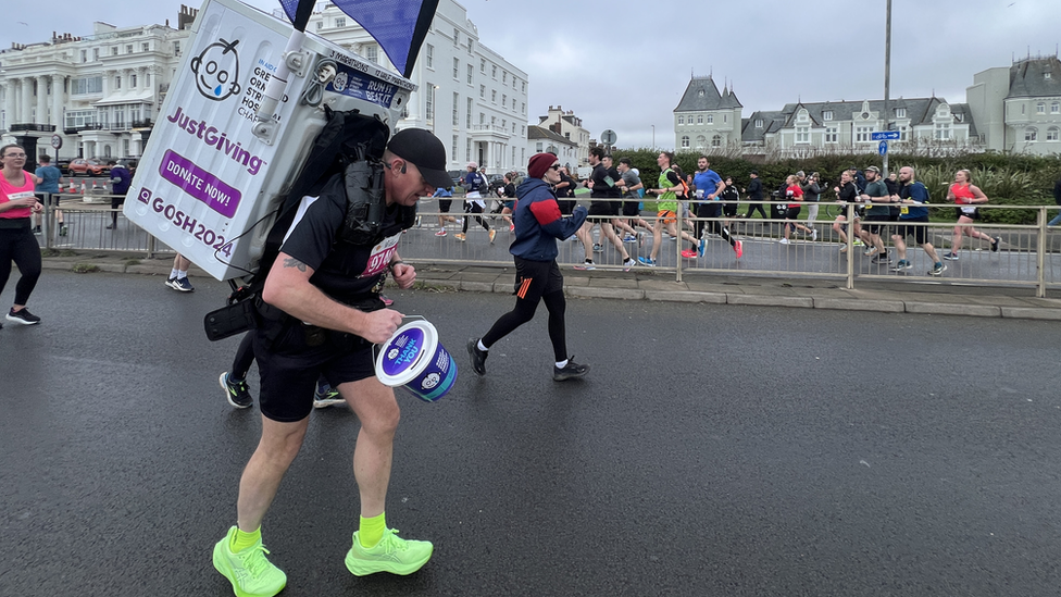 Runner with a washing machine on his back