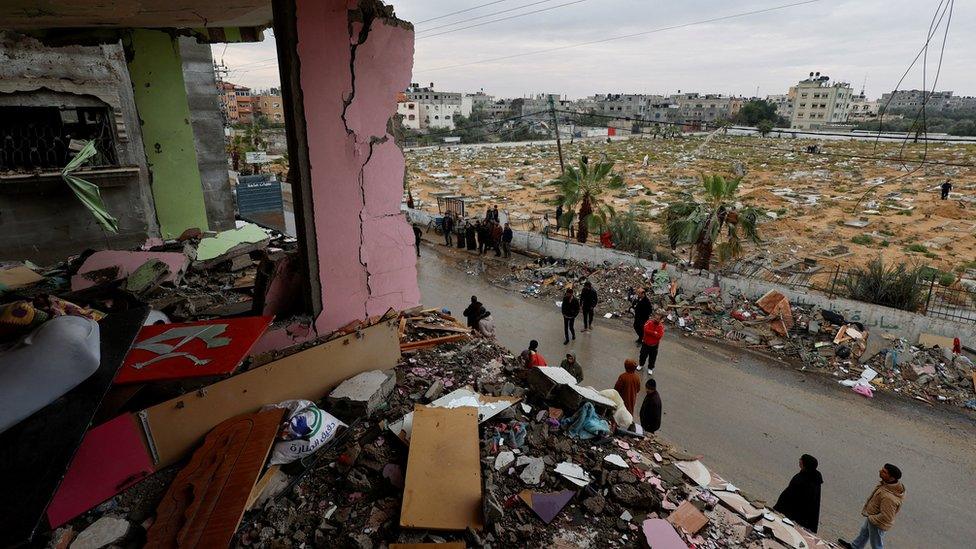 Palestinians inspect the site of an Israeli air strike on a residential building in Rafah, in the southern Gaza Strip (19 March 2024)